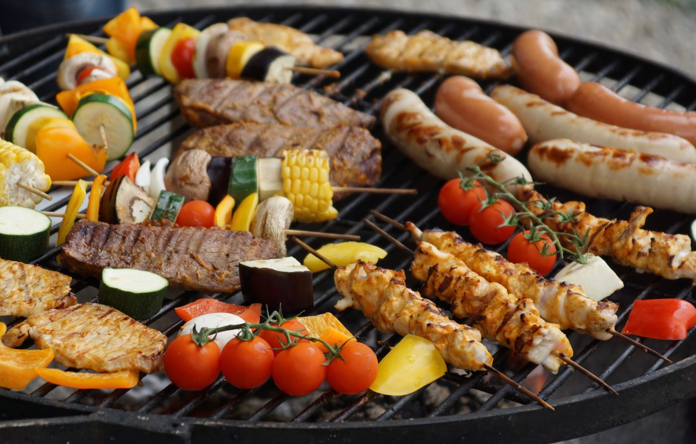 Voller Grill mit Steaks, Würstchen und Gemüsespießen